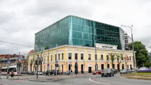 Moodne tramm sõitmas mööda Tallinna tänavat Metro Plaza hoone taustal.